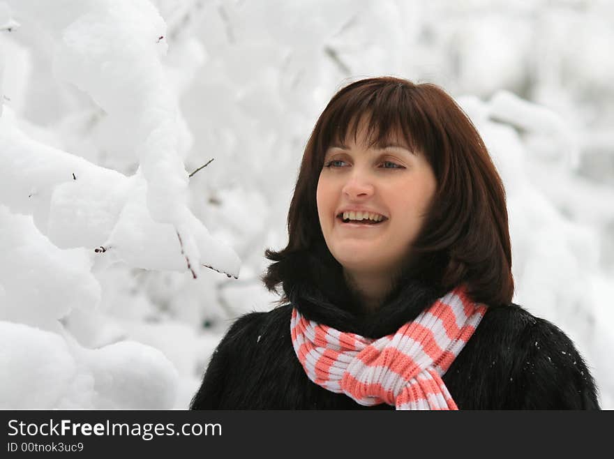 Portrait of the young woman under a falling snow