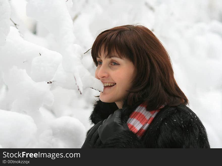 Portrait of the young woman under a falling snow