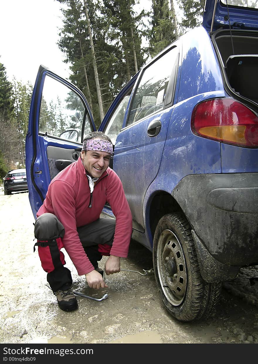 Man Resolving A Tyre Puncture