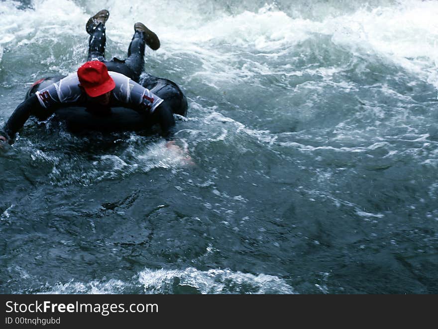 A man on an innertube going through some rapids. A man on an innertube going through some rapids