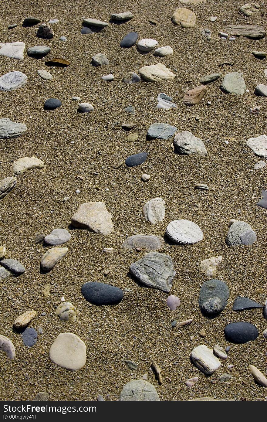 Texture of scattered pebbles on a sandy beach. Texture of scattered pebbles on a sandy beach