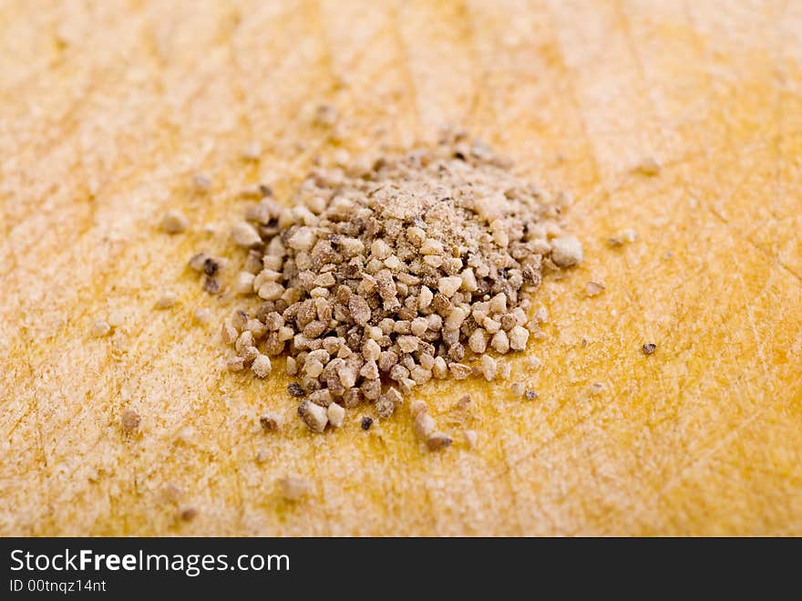 Pile of spice grains on a wooden board. Pile of spice grains on a wooden board