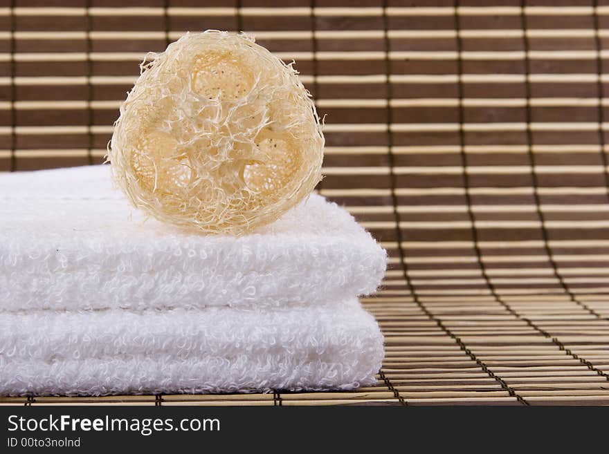 A natural sponge and two white towels