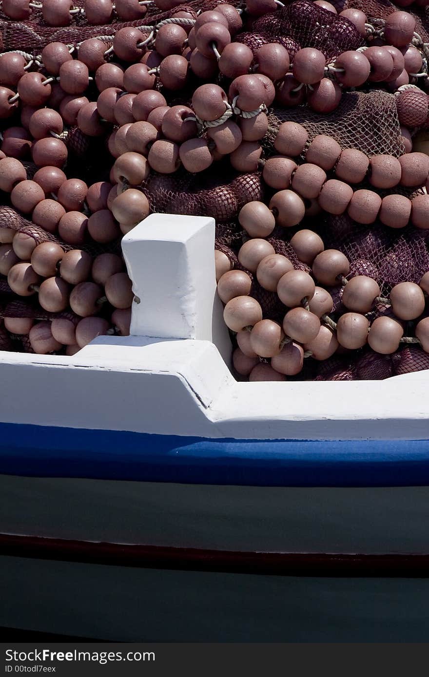 Detail of a red fishing net and floats on a greek fishing boat