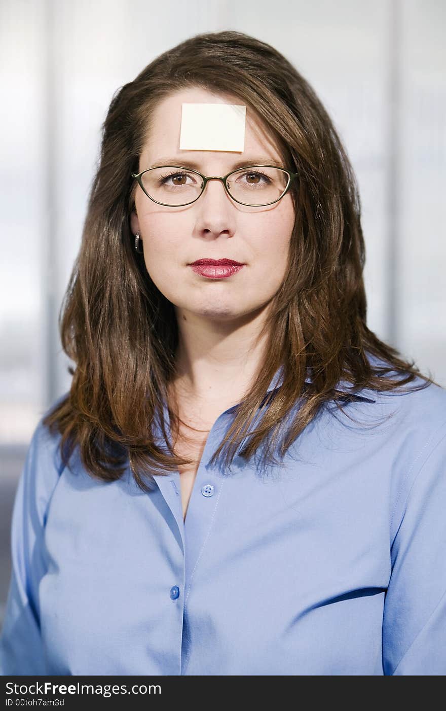 Businesswoman with a blank note on her forehead