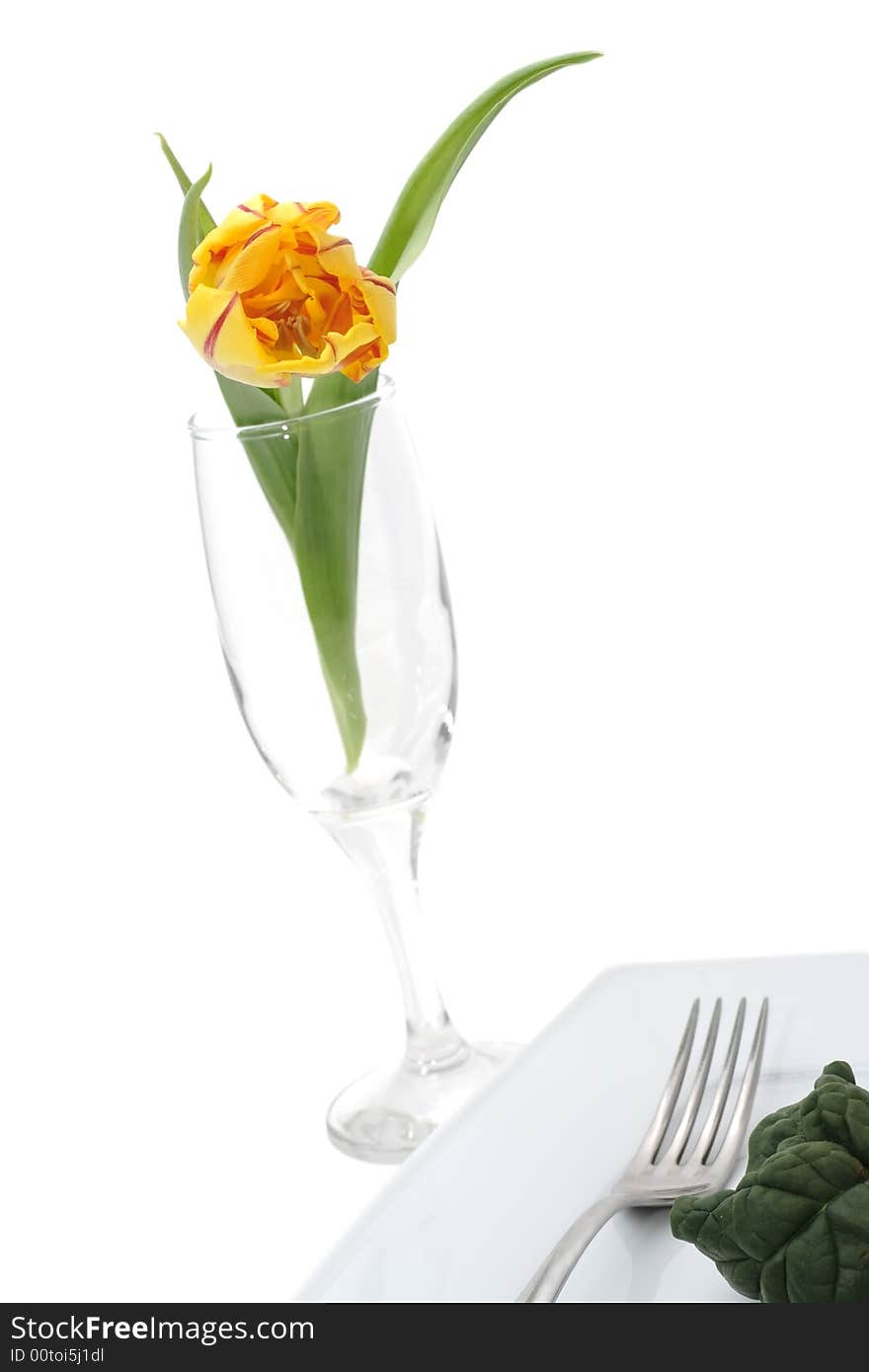 Still life of vegetables on a plete and flower in a glass. Still life of vegetables on a plete and flower in a glass