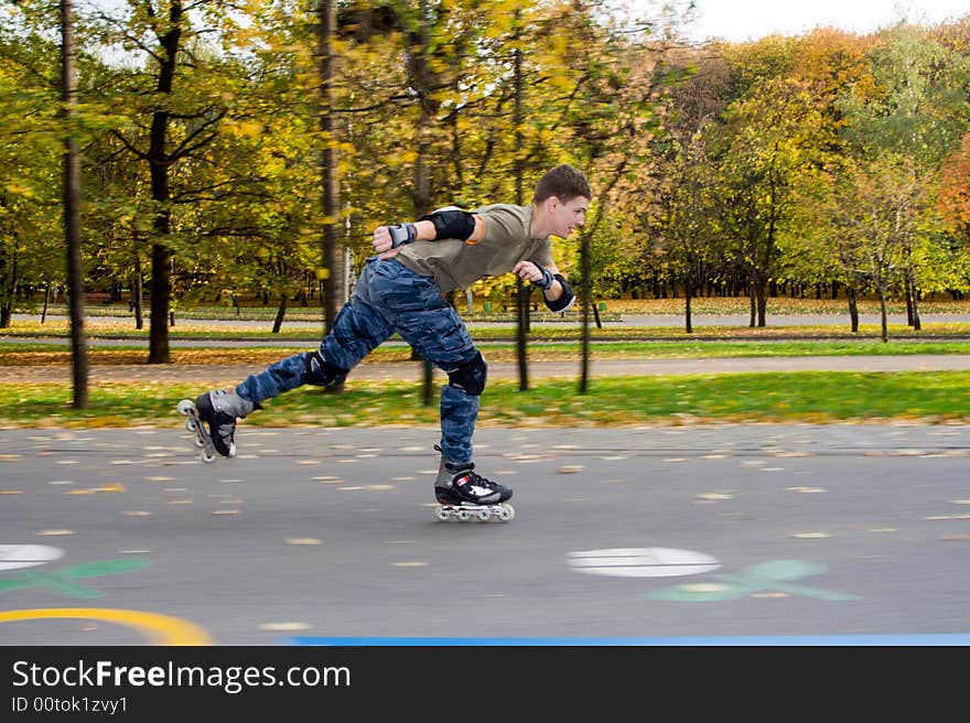 Roller skating at autumnal park.