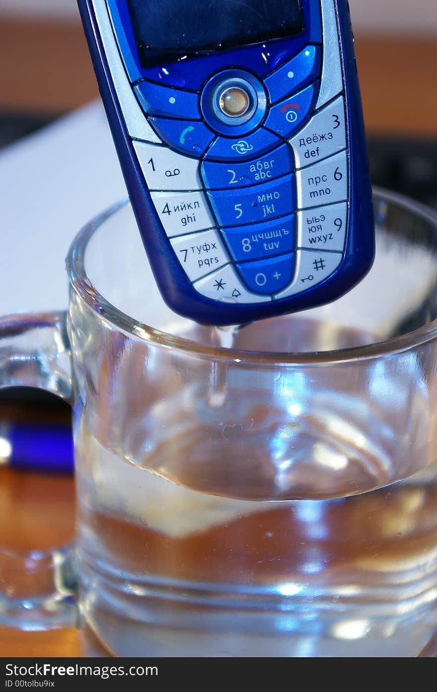 Broken mobile phone in a glass of water. Broken mobile phone in a glass of water