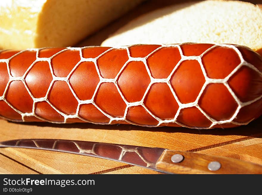 Sausage and bread on a kitchen board. Sausage and bread on a kitchen board