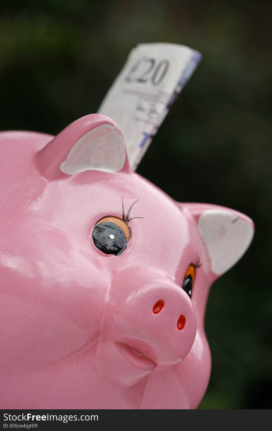 Pink piggy bank with a bank note about to pushed into the savings hole. Pink piggy bank with a bank note about to pushed into the savings hole