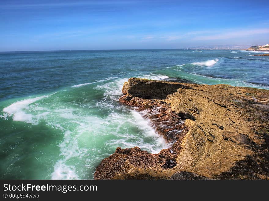 Aqua blue water crashing onto a rocky beach in San Diego.