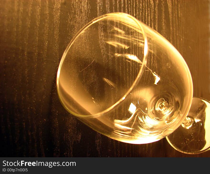 Glass to wine on wooden background in brown color.