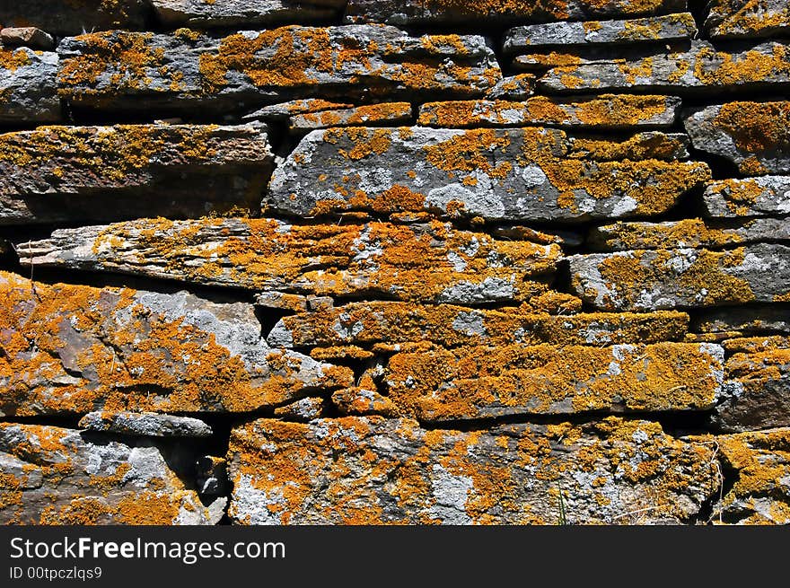 Old ancient mossy wall, moss all over, stone was used as bricks. Old ancient mossy wall, moss all over, stone was used as bricks