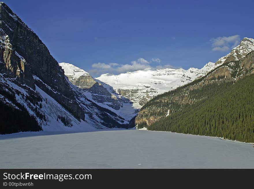 Lake louise frozen over with bright blue sky in background