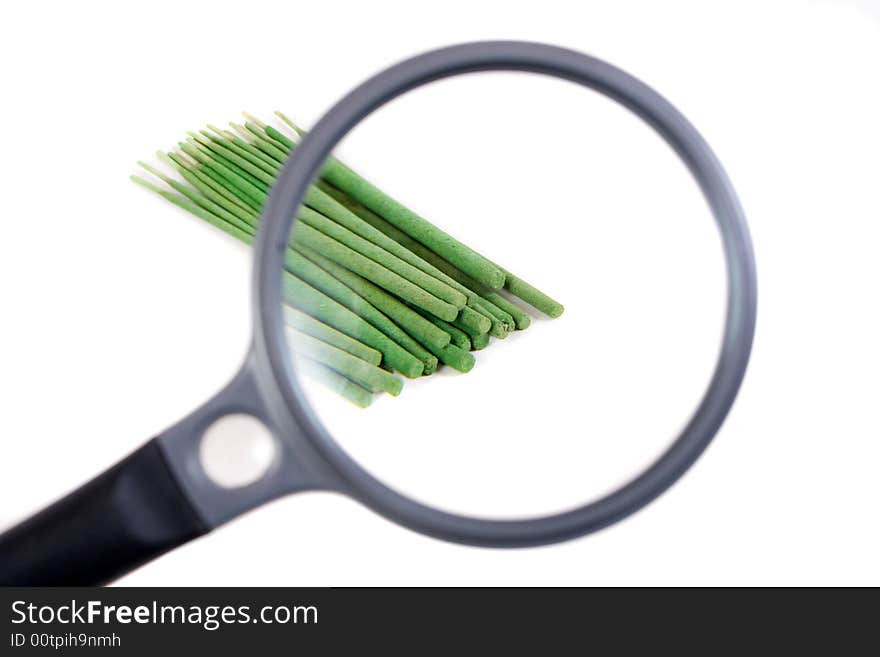 Incense sticks seen through magnifier.Isolated on white background.