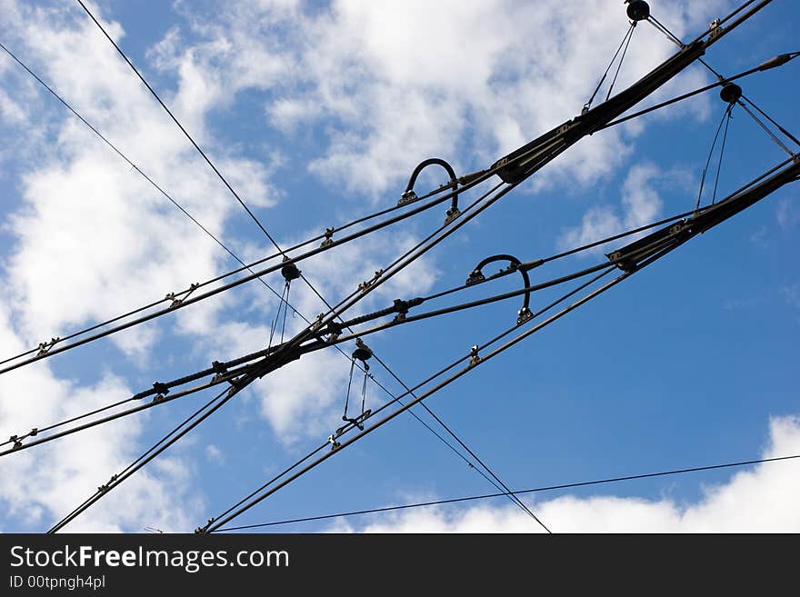 Suspended tramway power cables against blue sky with clouds. Suspended tramway power cables against blue sky with clouds