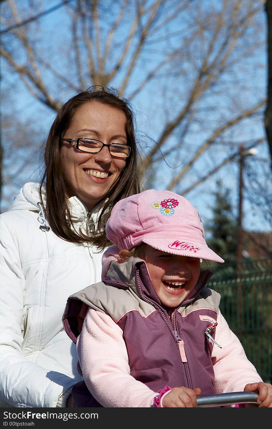 Young girl and children smiling in tandem seesaw.