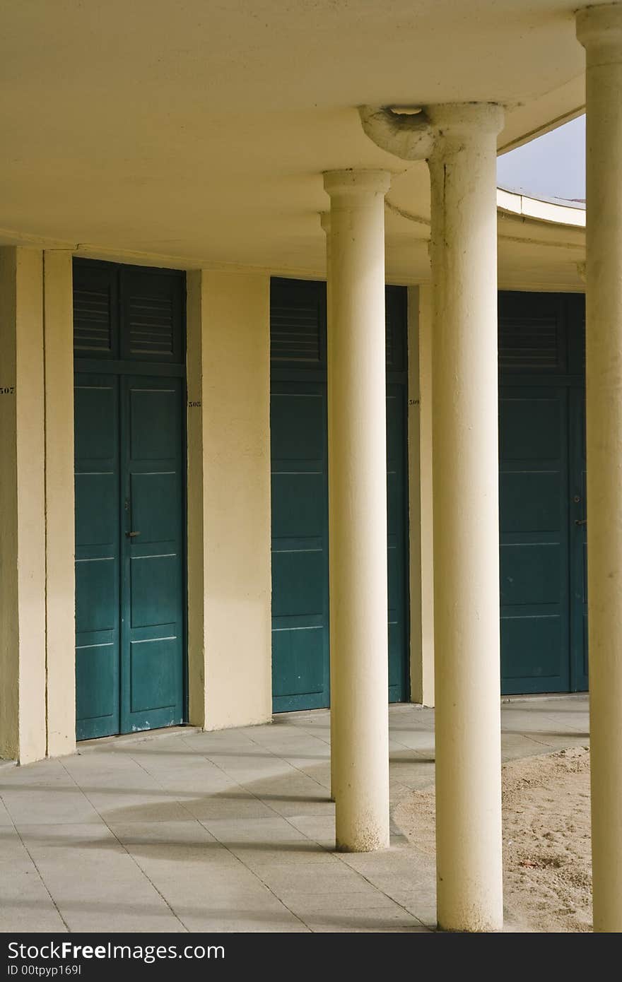 Yellow classical building with columns and green doors in France