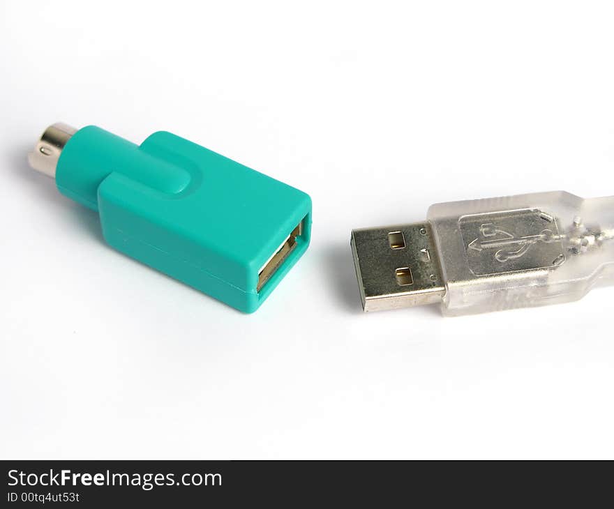 Green usb to ps2 connector and a usb cable in a white background. Isolated photo.