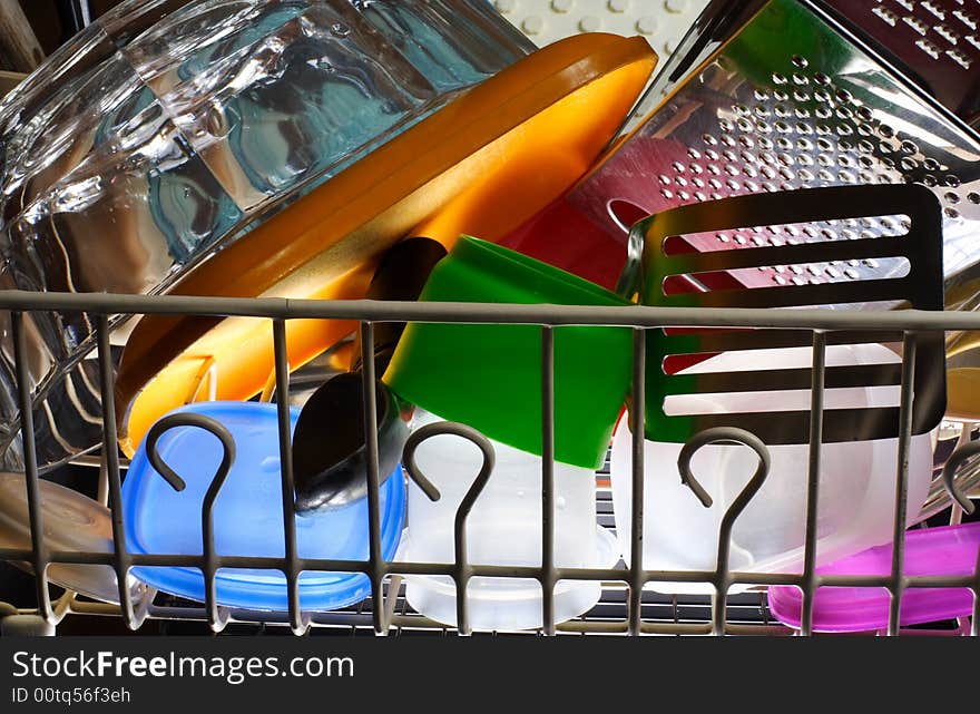 Colorful kitchen items sit in a drying rack.