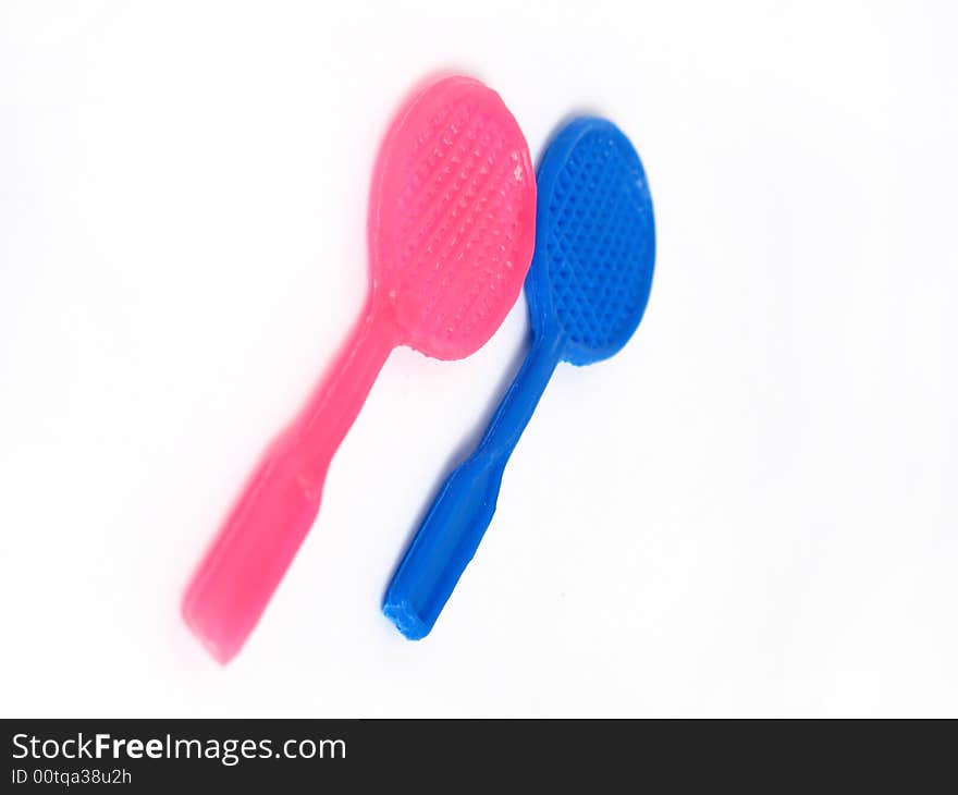 Two tennis racket toys, blue and pink. Isolated photo.