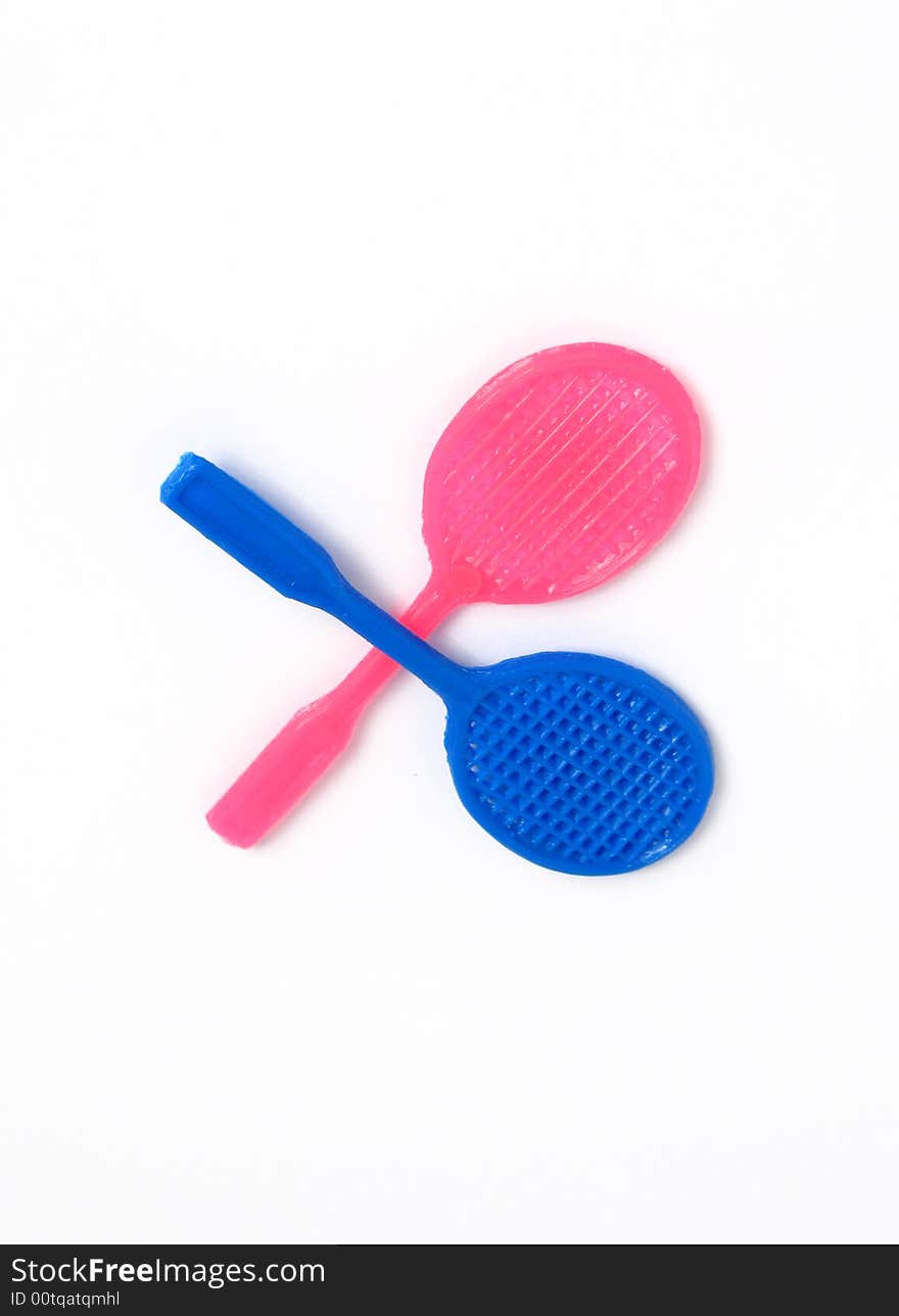 Two tennis racket toys, blue and pink. Isolated photo.