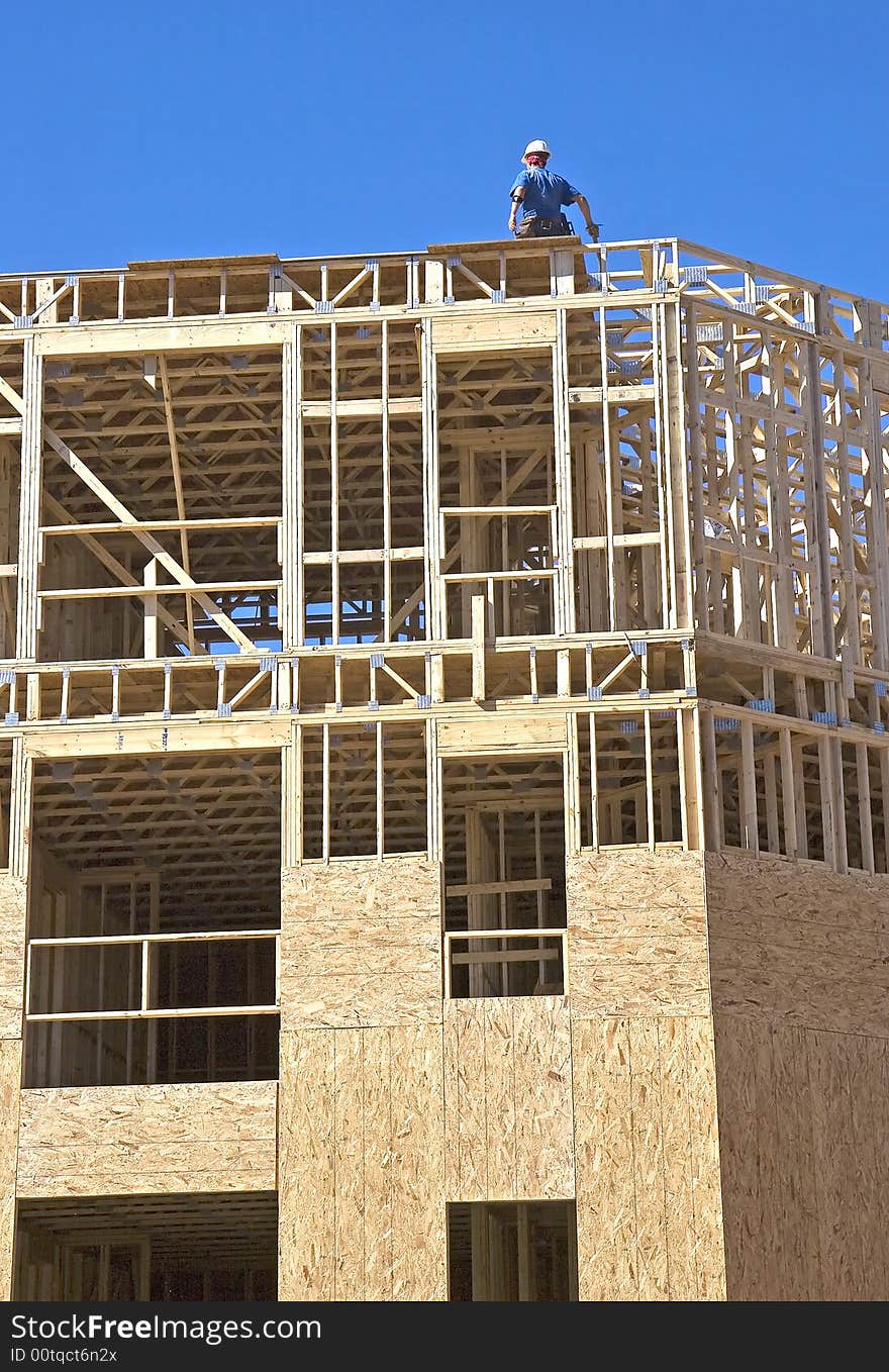 A framer on a wood structure under construction. A framer on a wood structure under construction