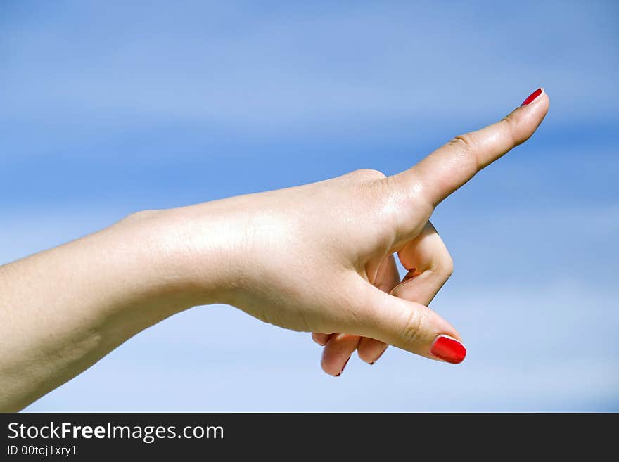 Woman hand show direction on blue sky background. Woman hand show direction on blue sky background