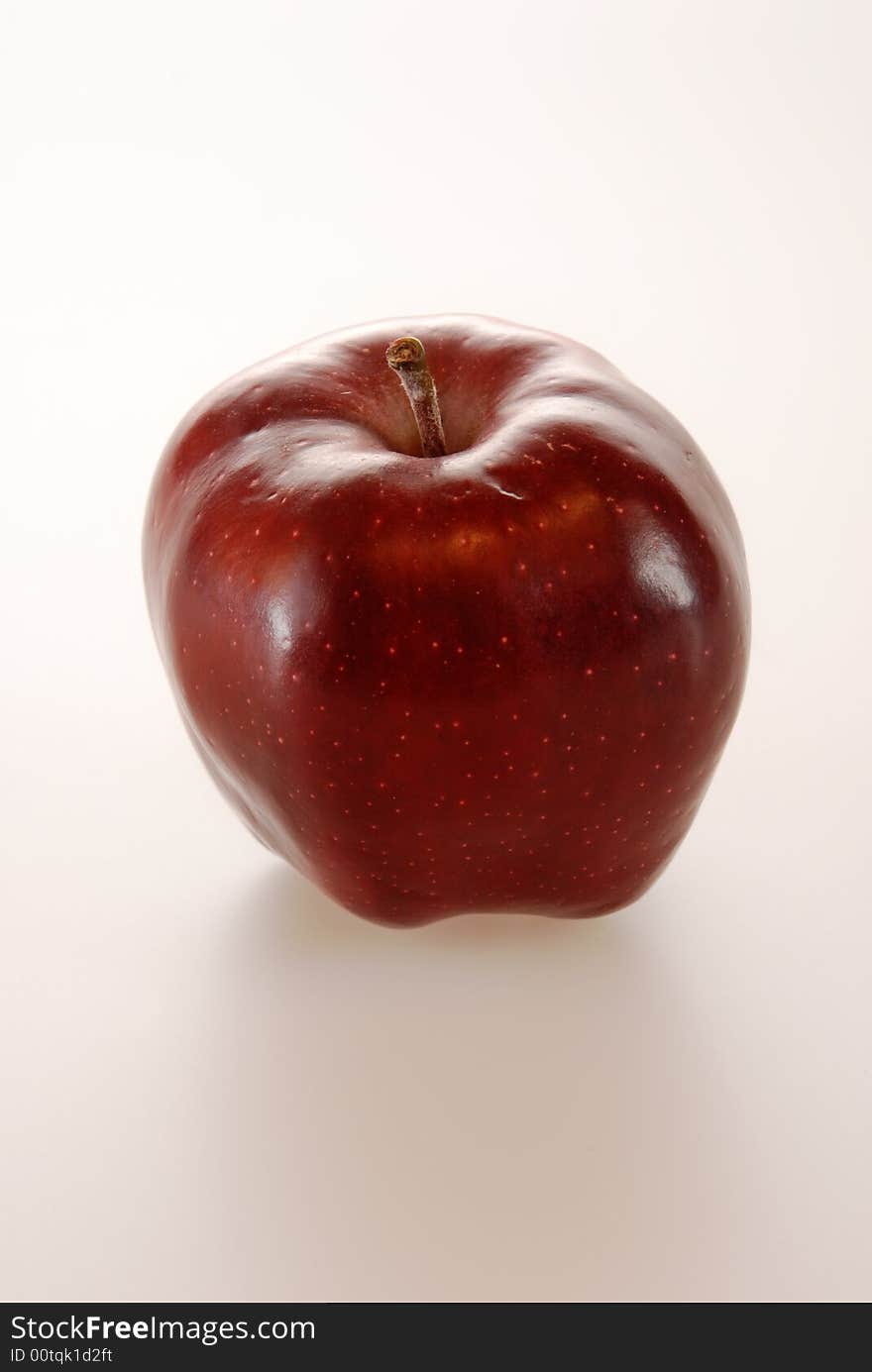 A juicy deep red shiny apple isolated on white. A juicy deep red shiny apple isolated on white.