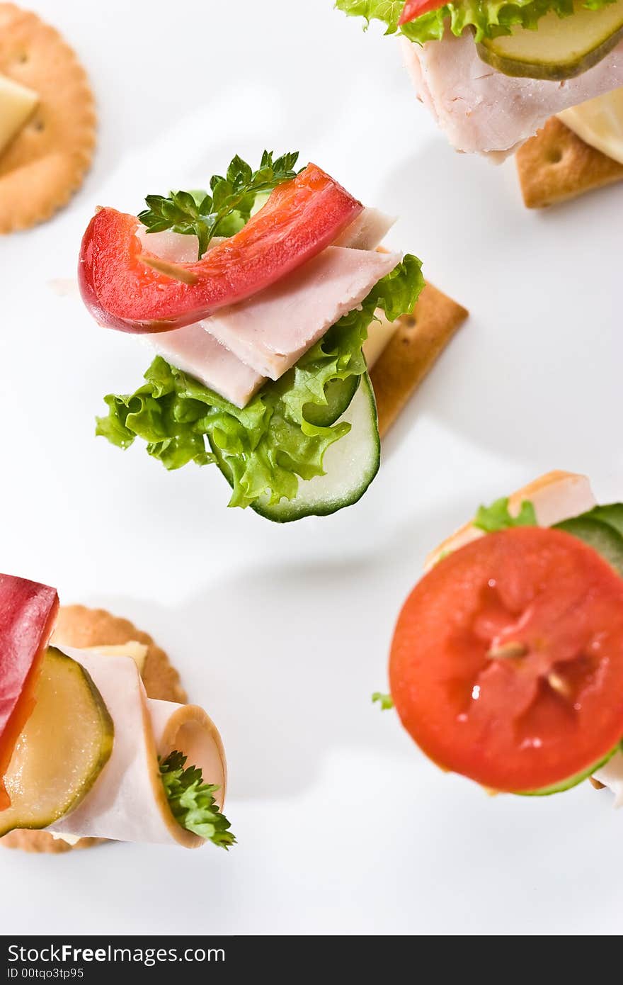 Food theme: cracker with ham, cheese and vegetables on the plate. Food theme: cracker with ham, cheese and vegetables on the plate