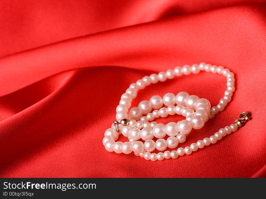 Beautiful pearl necklace over red background