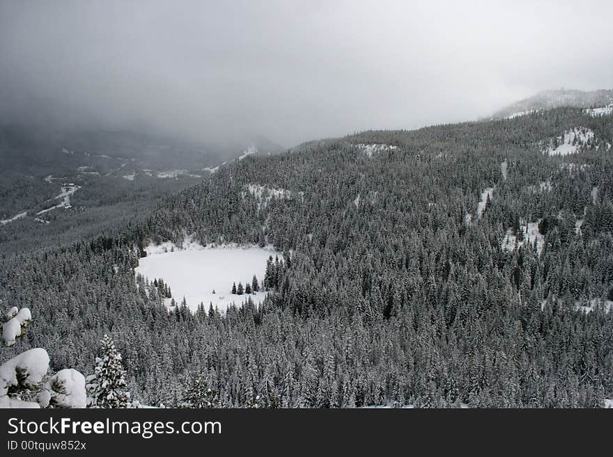 Frozen lake nestled in winter wonderland