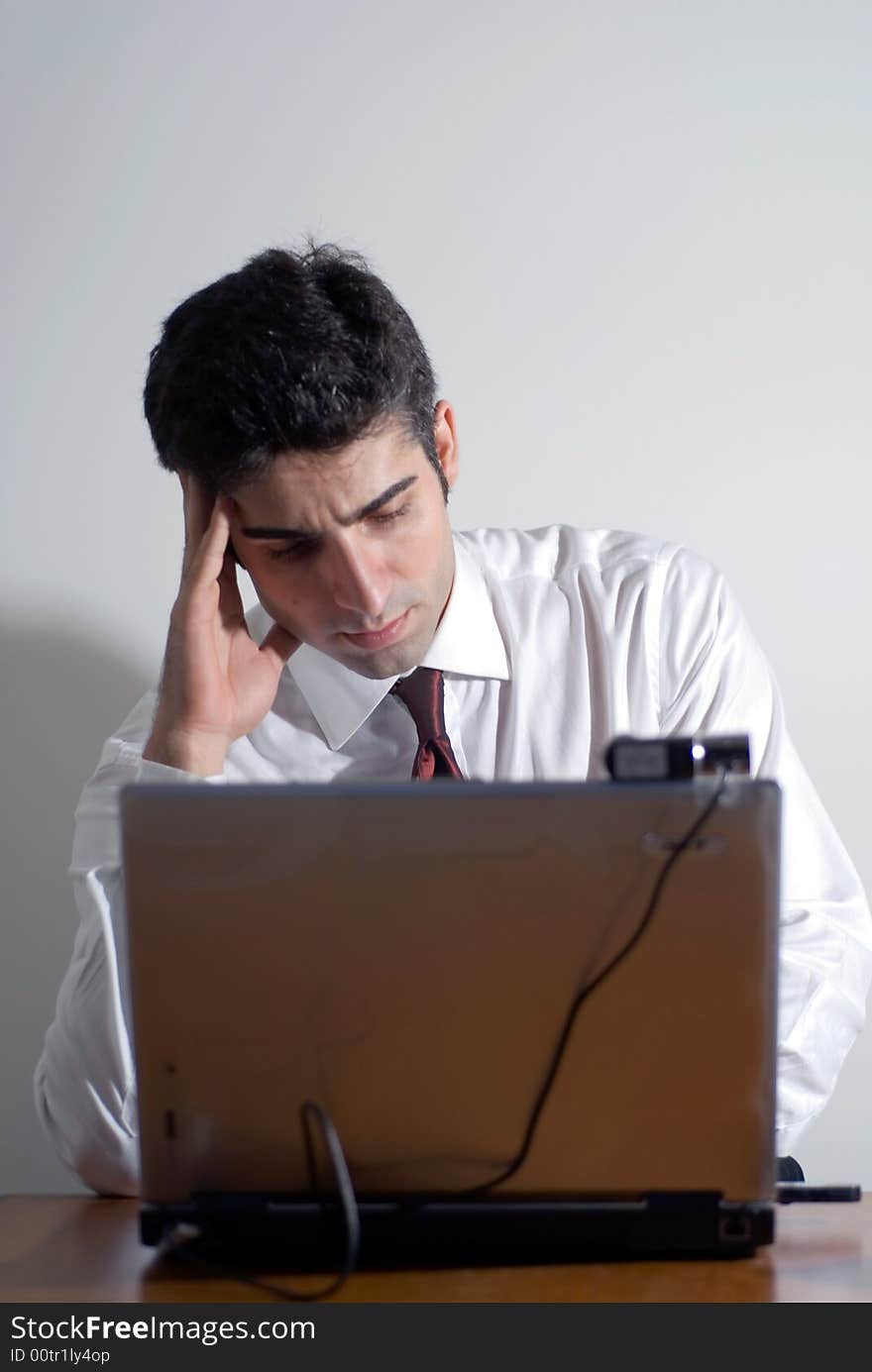 Man in a shirt and tie working late isolated against a white background