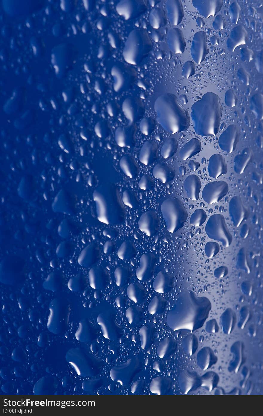 Natural water drops on blue glass