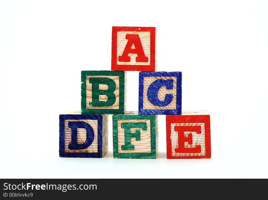 Alphabet wood blocks forming a pyramid over a white background. Alphabet wood blocks forming a pyramid over a white background