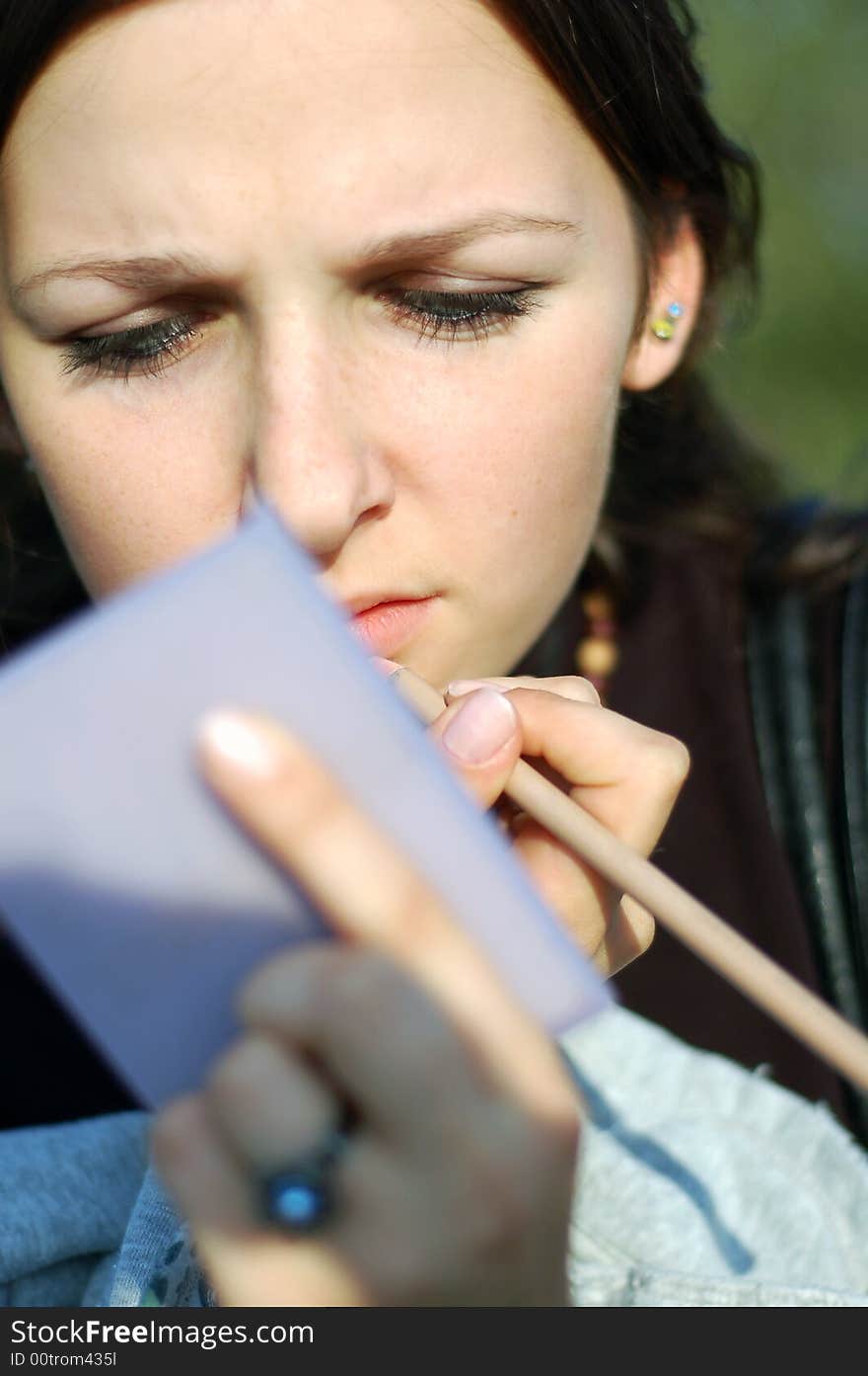 Teenage girl during make-up and watching in a mirror. Teenage girl during make-up and watching in a mirror