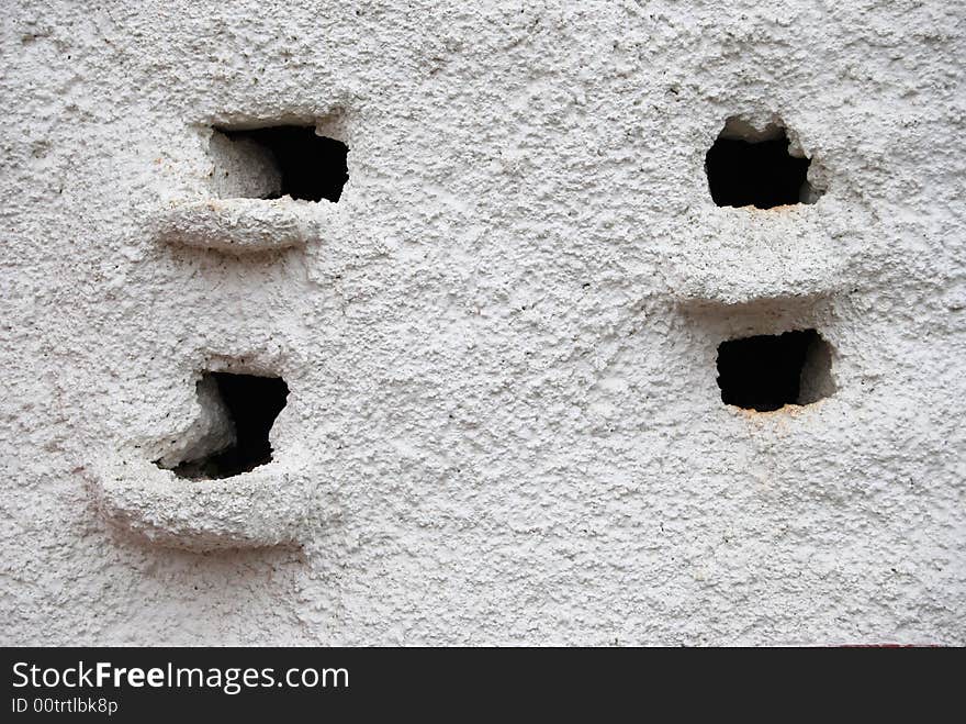 A pigeon coop in a white wall