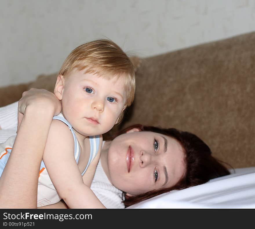 Young mum with the small beautiful son lay on a sofa. Young mum with the small beautiful son lay on a sofa