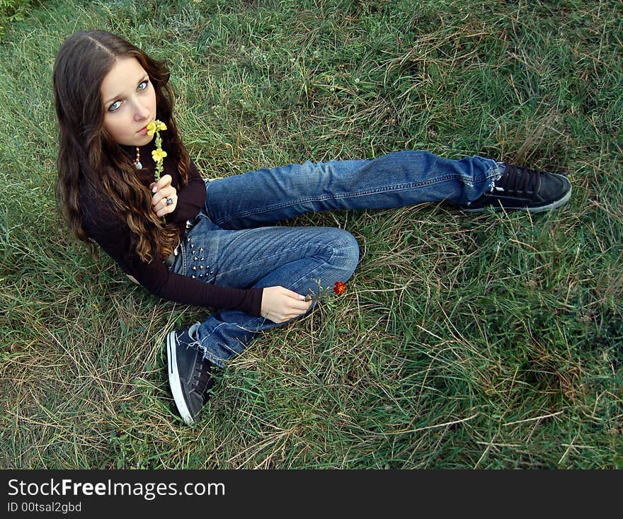 Beautiful teenage girl sitting on the grass