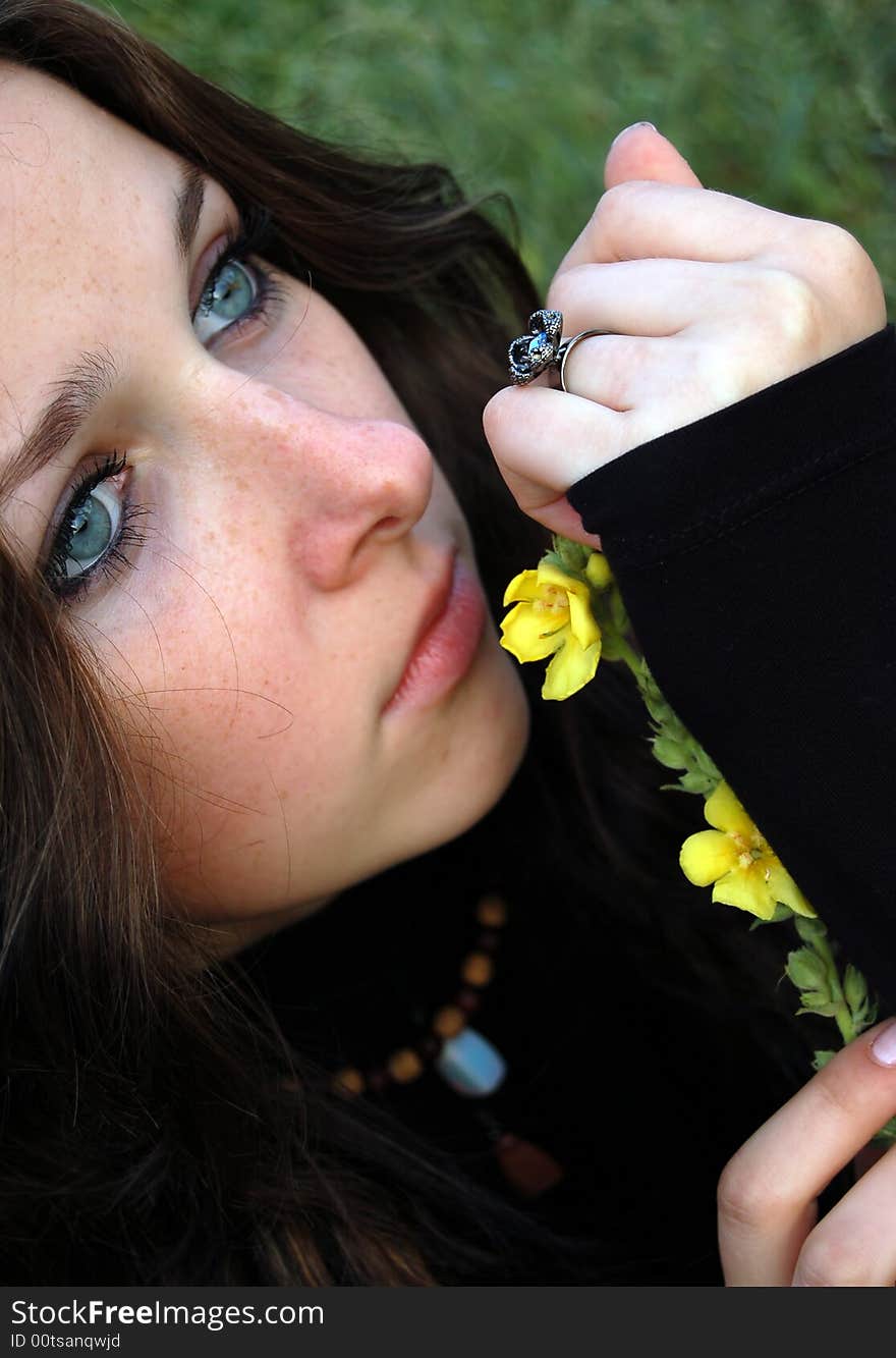 Beautiful teenage girl playing with a flower