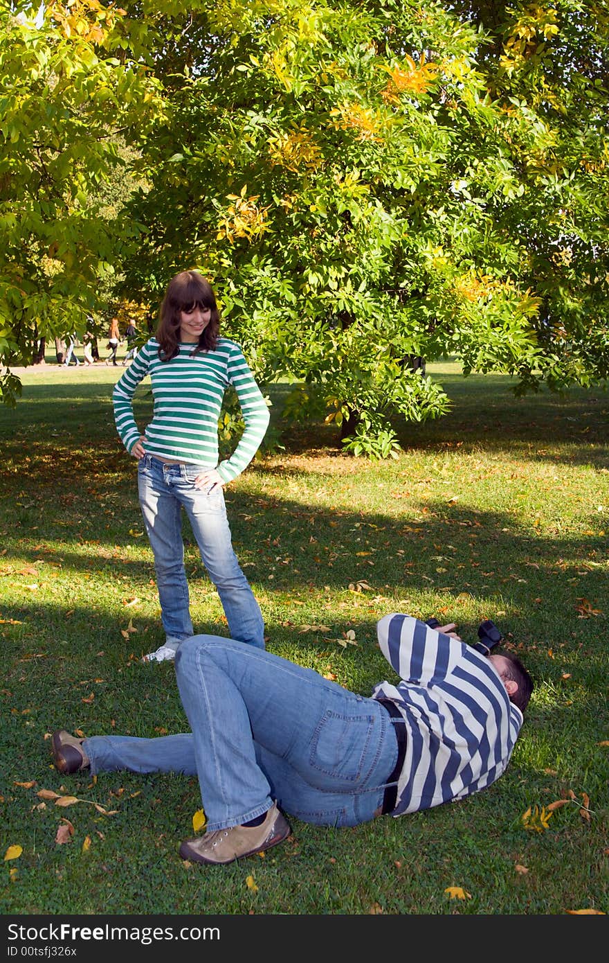 Amateur photographer take a photo of young woman in a park. Amateur photographer take a photo of young woman in a park