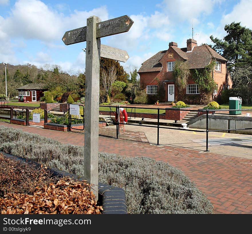 Lock and Lock Keepers House on the Thames River Path in England with Footpath sign in the foreground. Lock and Lock Keepers House on the Thames River Path in England with Footpath sign in the foreground