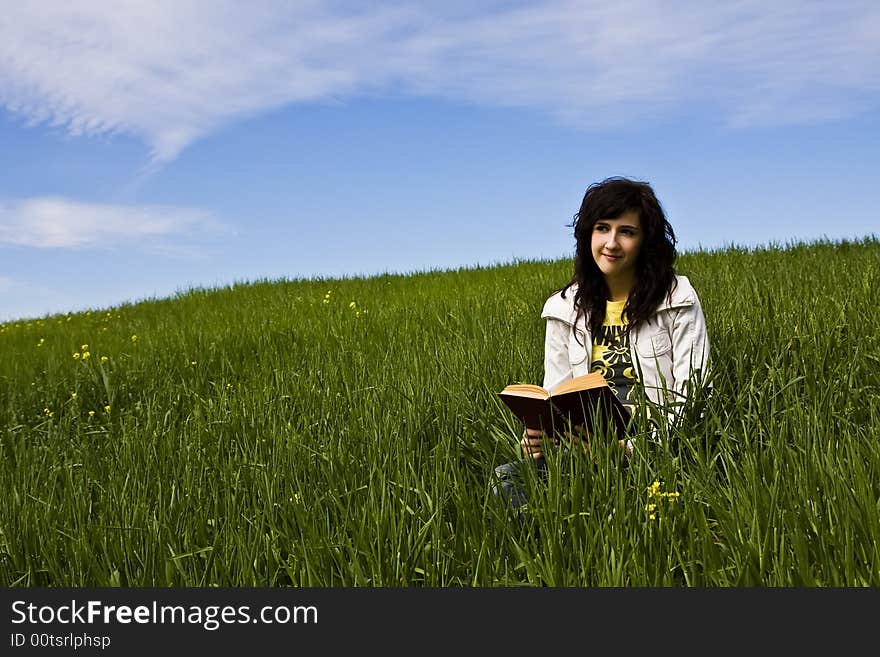 Young woman reading a book in the park