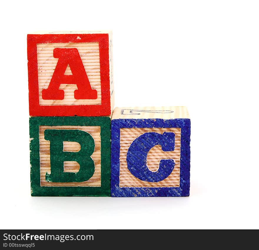 Letter wood blocks forming the sequence abc on a white surface