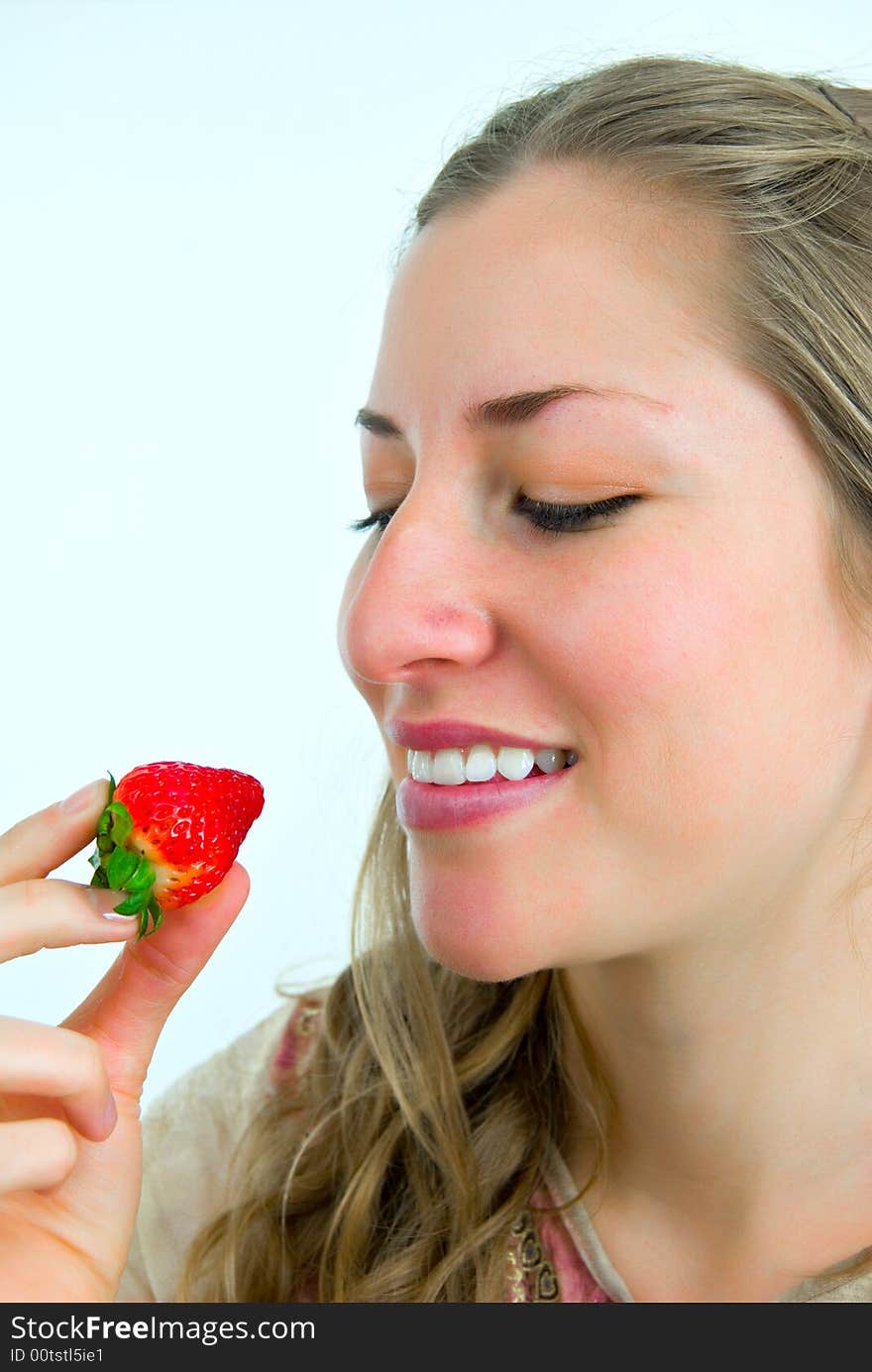 Sweet girl looking at a red strawberry