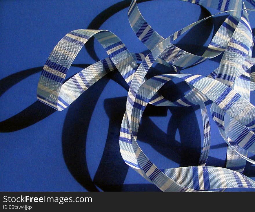 Blue striped ribbon against blue background. Blue striped ribbon against blue background