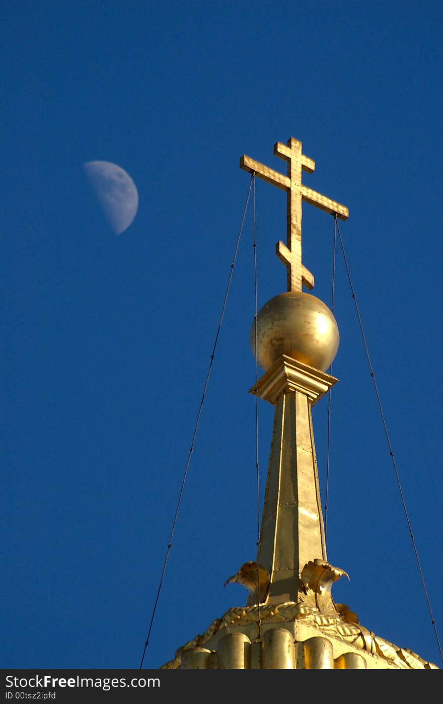 Golden orthodox cross on blue sky with moon. Golden orthodox cross on blue sky with moon.