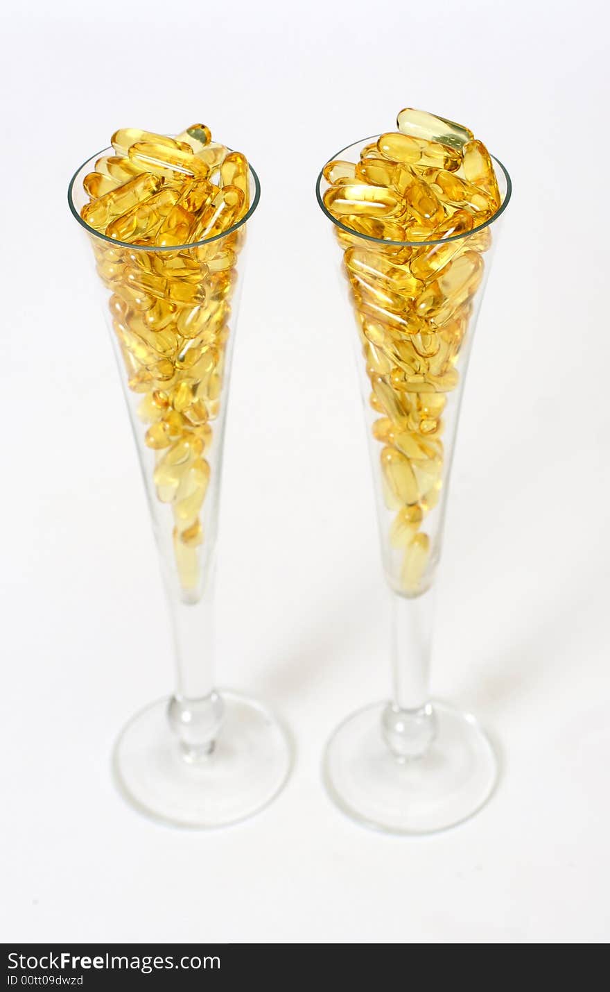 Two glasses with gold shiny boluses. Two glasses with gold shiny boluses