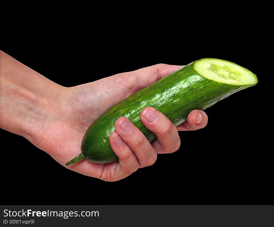 Hand holding a cucumber on black background