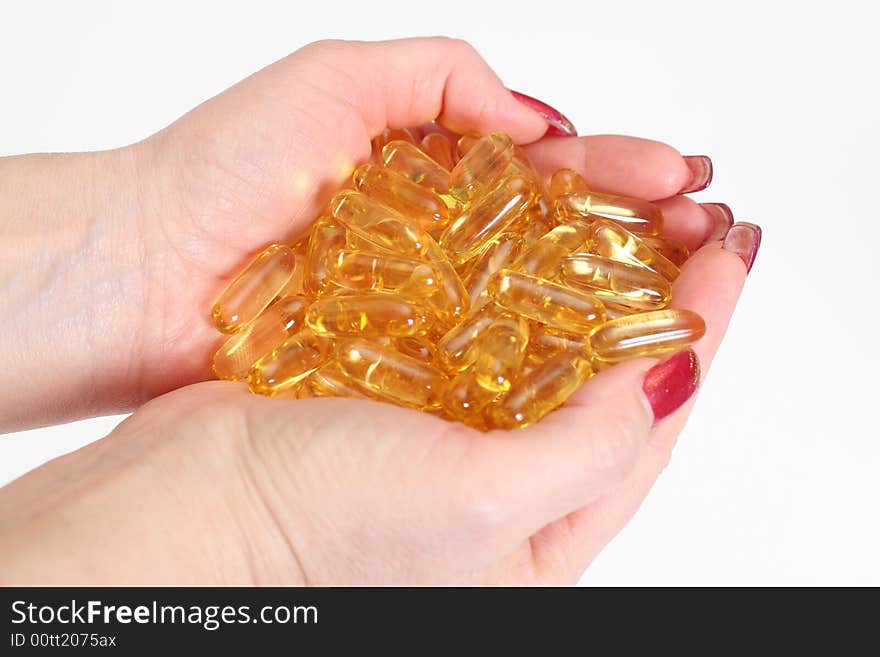 Woman's hands holding gold shiny boluses. Woman's hands holding gold shiny boluses